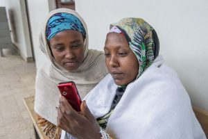 Ethiopian health care workers using red mobile phone